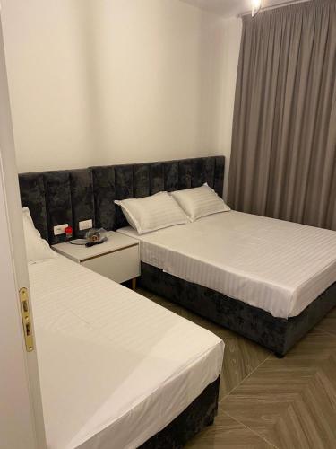 a hotel room with two beds and a window at AJ Apartments in Orikum