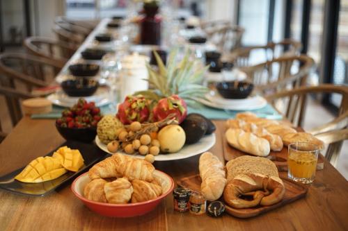 a long table topped with plates of bread and pastries at Private Pool Villa 88 Nimman Chiangmai in Chiang Mai