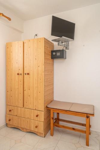 a room with a wooden cabinet and a bench and a tv at Fiore Di Mare Studios in Lassi