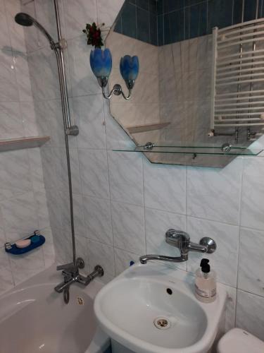 a bathroom with a sink and a toilet and a tub at Wakacyjny apartament in Hel