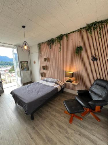 - une chambre avec un lit et deux chaises dans l'établissement Studio meublé en Centre Ville avec vue sur la Dent du Chat, à Aix-les-Bains