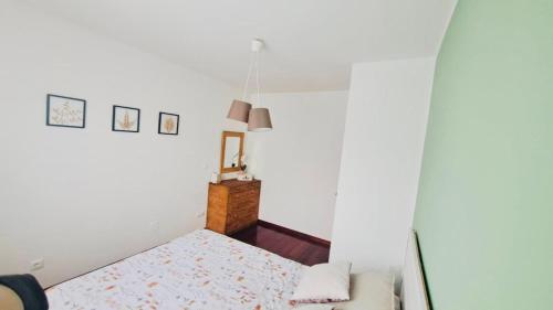 a white bedroom with a bed and a couch at Elegante Adosado en Ampuero in Rasines
