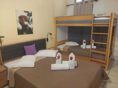 two beds in a room with two bunk beds at Evelina Family Beach Pension a breath away from the Black Beach offer plenty of accommodation type to suit every traveler's needs-Economic Rooms-Thematic Rooms-Design Rooms-Kitchenette Rooms-Studios-Small Apartments in Perissa
