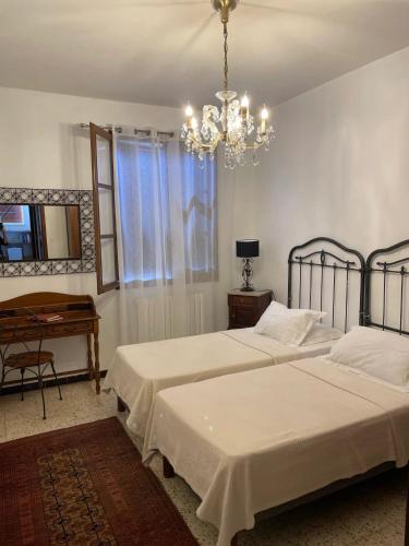 sypialnia z 2 łóżkami i żyrandolem w obiekcie Maison accueillante avec vue sur la mer à Grosseto-Prugna w mieście Grosseto-Prugna