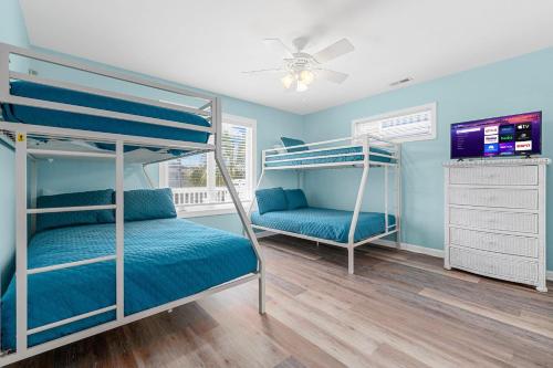 a bedroom with two bunk beds and a flat screen tv at Kokomo in Myrtle Beach