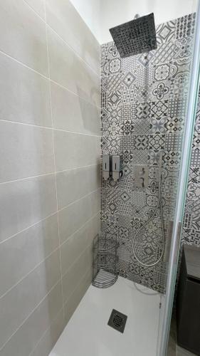a bathroom with a shower with a tile wall at Jenka in Caltabellotta