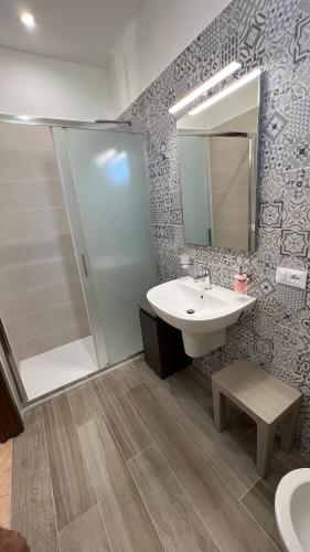 a bathroom with a sink and a shower and a mirror at Jenka in Caltabellotta