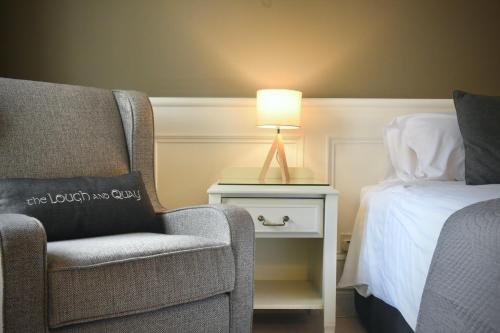 a bedroom with a chair and a bed and a lamp at The Lough & Quay Accommodation in Warrenpoint