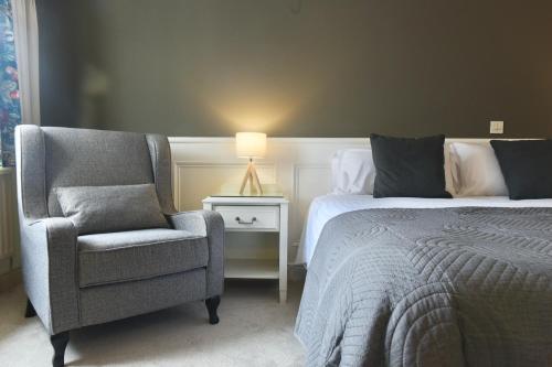 a bedroom with a bed and a chair and a lamp at The Lough & Quay Accommodation in Warrenpoint
