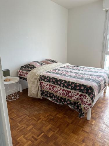 - une chambre avec 2 lits et une table sur du parquet dans l'établissement Merville, à Lorient