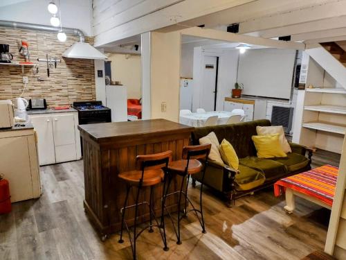 Una cocina y una sala de estar con un sofá y una mesa. en Casas La Violeta, en Villa La Angostura
