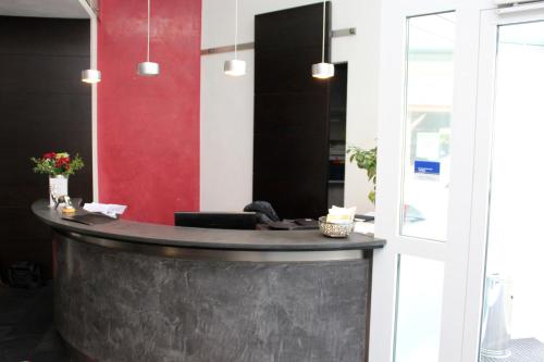 a bar in a room with a red wall at Hotel am Hirschgarten in Filderstadt