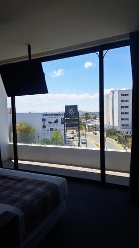 a bedroom with a large window with a view of a street at Kharma Suites in Puebla