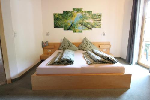 a bed in a room with a painting on the wall at Landhaus Müller in Neustift im Stubaital