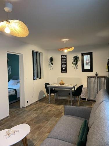 un salon avec un canapé, une table et un lit dans l'établissement Charmante maison sur propriété, à Orly