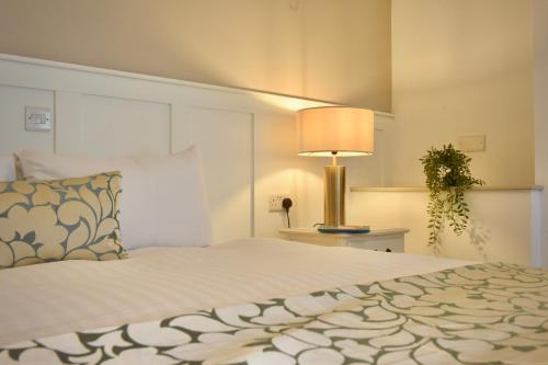a bedroom with a large bed with a lamp on it at The Lough & Quay Accommodation in Warrenpoint