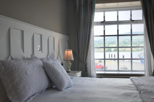 a bedroom with a bed and a large window at The Lough & Quay Accommodation in Warrenpoint