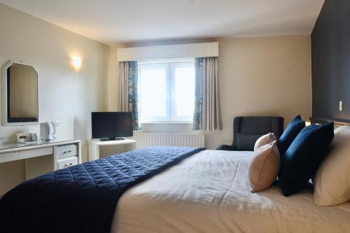 a bedroom with a large bed and a television at The Lough & Quay Accommodation in Warrenpoint
