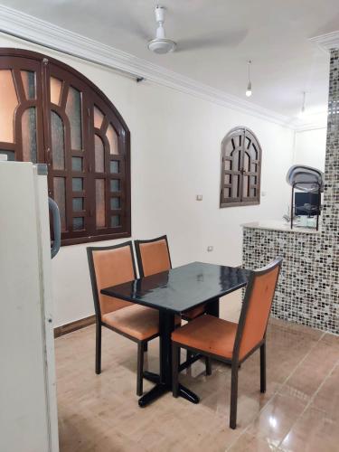 a dining room with a black table and chairs at Modern Apartment in Luxor in Luxor