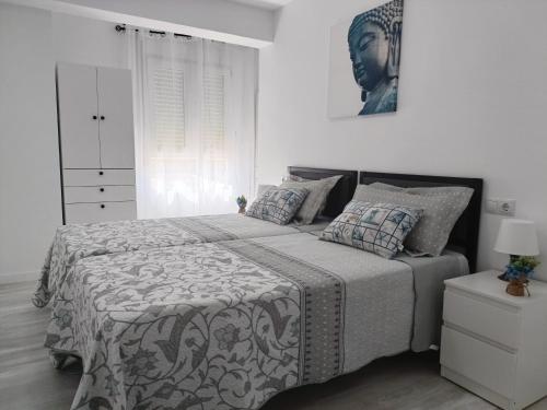 ein Schlafzimmer mit einem Bett mit einer schwarz-weißen Bettdecke in der Unterkunft Mare de Deu, vivienda vacacional para familias y mayores de 25 años en el Grao de Gandia-Playa in Puerto de Gandía
