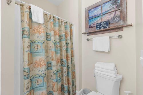 a bathroom with a shower curtain and a toilet at Shealy's Seaclusion in Myrtle Beach