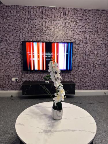 a vase with flowers on a table in a room at 2 bed luxury apartment in Wolverhampton