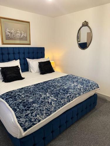 a bed with a blue headboard in a bedroom at 2 bed luxury apartment in Wolverhampton