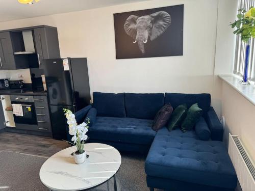 a living room with a blue couch and a table at 2 bed luxury apartment in Wolverhampton