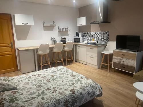 - une cuisine avec des placards blancs et des tabourets de bar dans une pièce dans l'établissement La nuit étoilée, à Rocroi