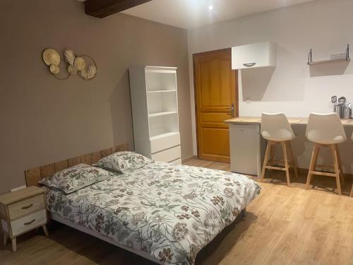 Cet appartement comprend une chambre avec un lit et une cuisine avec deux tabourets. dans l'établissement La nuit étoilée, à Rocroi