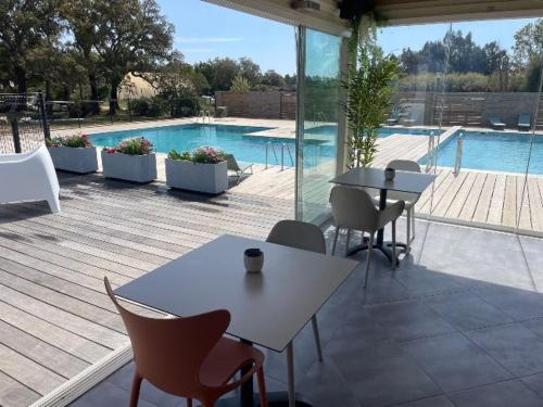 un patio avec tables et chaises et une piscine dans l'établissement Villa di Caju - 4-6 personnes - les Hameaux de Saint Cyprien - lecci, à Lecci