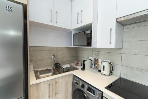 SummerstrandにあるModern Apartment Near The Beachのキッチン(白いキャビネット、洗濯機付)