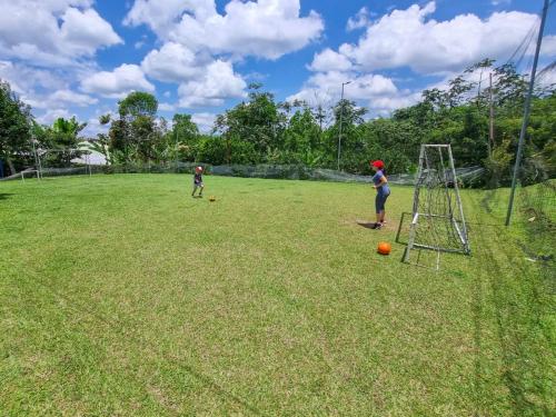 two children playing with balls in a field at Hotel Campestre Alto Bonito del Quindío in El Cuzco
