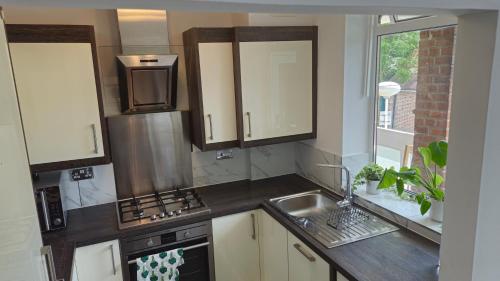 una cocina con fregadero y estufa en Bright Spacious Airy 2 Bed Flat, en Ealing