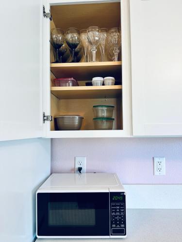 a microwave in a cupboard with glasses in it at Audrey in Salem