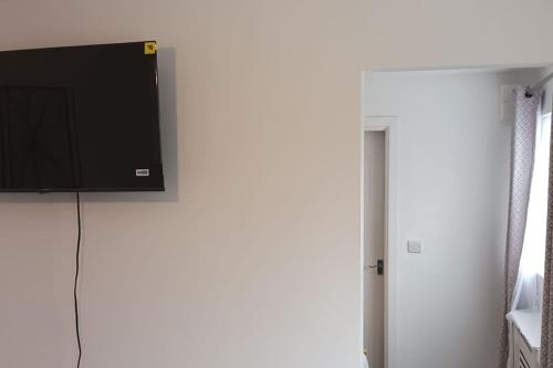 a flat screen tv hanging on a wall at Newly built home away from home in Peterborough