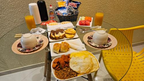 Henry's Motel في أركوفيردي: طاولة زجاجية عليها صحون طعام