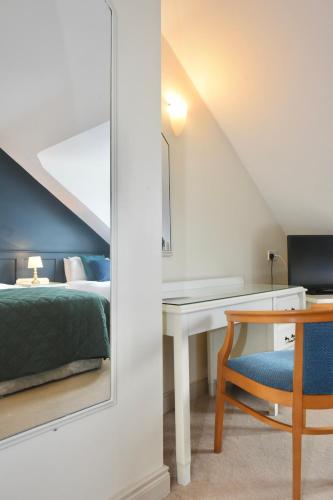 a bedroom with a bed and a desk with a mirror at The Lough & Quay Accommodation in Warrenpoint