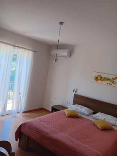 a bedroom with a red bed and a window at Apartman Suzy in Pula