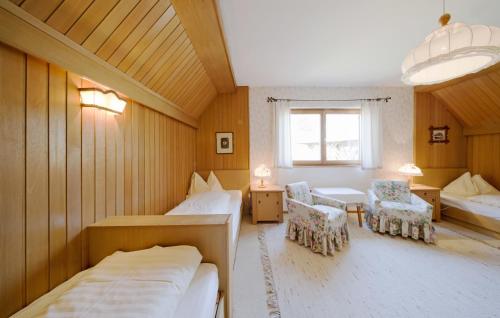 デラッハにあるFerienhaus Goldbergのベッド2台、椅子2脚、窓が備わる客室です。
