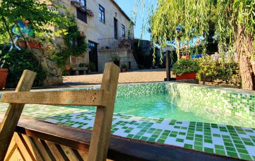 a bench sitting next to a swimming pool at Casa do Fundo - Sustainable & Ecotourism in Seia