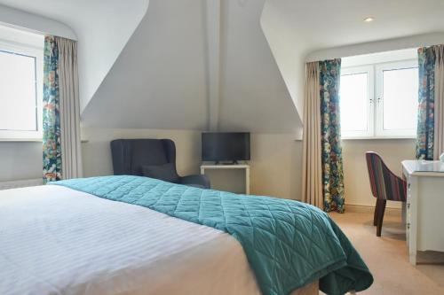 a bedroom with a bed and a desk and chairs at The Lough & Quay Accommodation in Warrenpoint