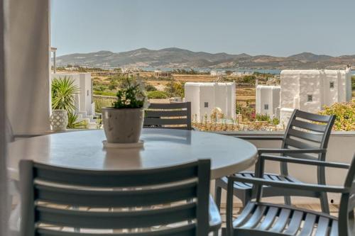 un tavolo con sedie e una pianta in vaso sul balcone di Villa Manios Glisidia sea view a Kampos Paros
