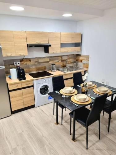 a kitchen with a table with chairs and a stove at Appartement Neuf Rénové in Rive-de-Gier