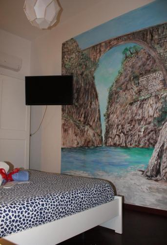 a bedroom with a painting on the wall at I 7 MARI home in Salerno
