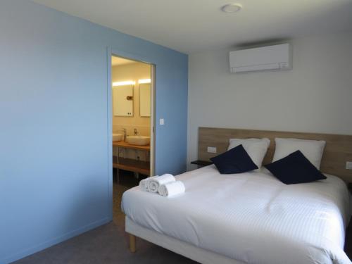 a bedroom with a white bed and a bathroom at Hôtel les Jardins de Saulzet in Romagnat
