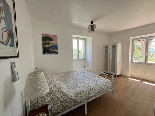 - une chambre avec un lit et une lampe dans l'établissement 3 pièces au dernier étage dans bastide grassoise, à Grasse