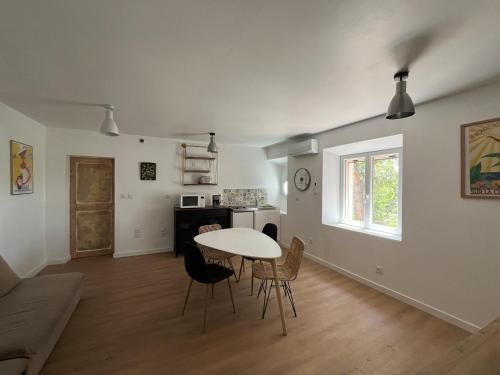 un salon avec une table et des chaises et une cuisine dans l'établissement 3 pièces au dernier étage dans bastide grassoise, à Grasse