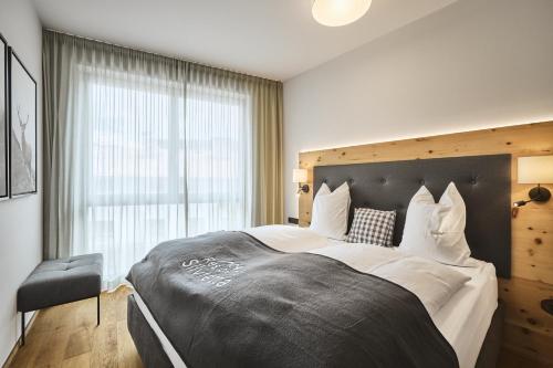 een slaapkamer met een groot bed met een groot raam bij Stilvolle Luxuswohnung in der Residenz Silvretta in See