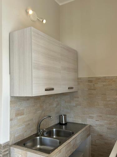 a kitchen with a sink and a wooden cabinet at Villa Nobile in Siracusa